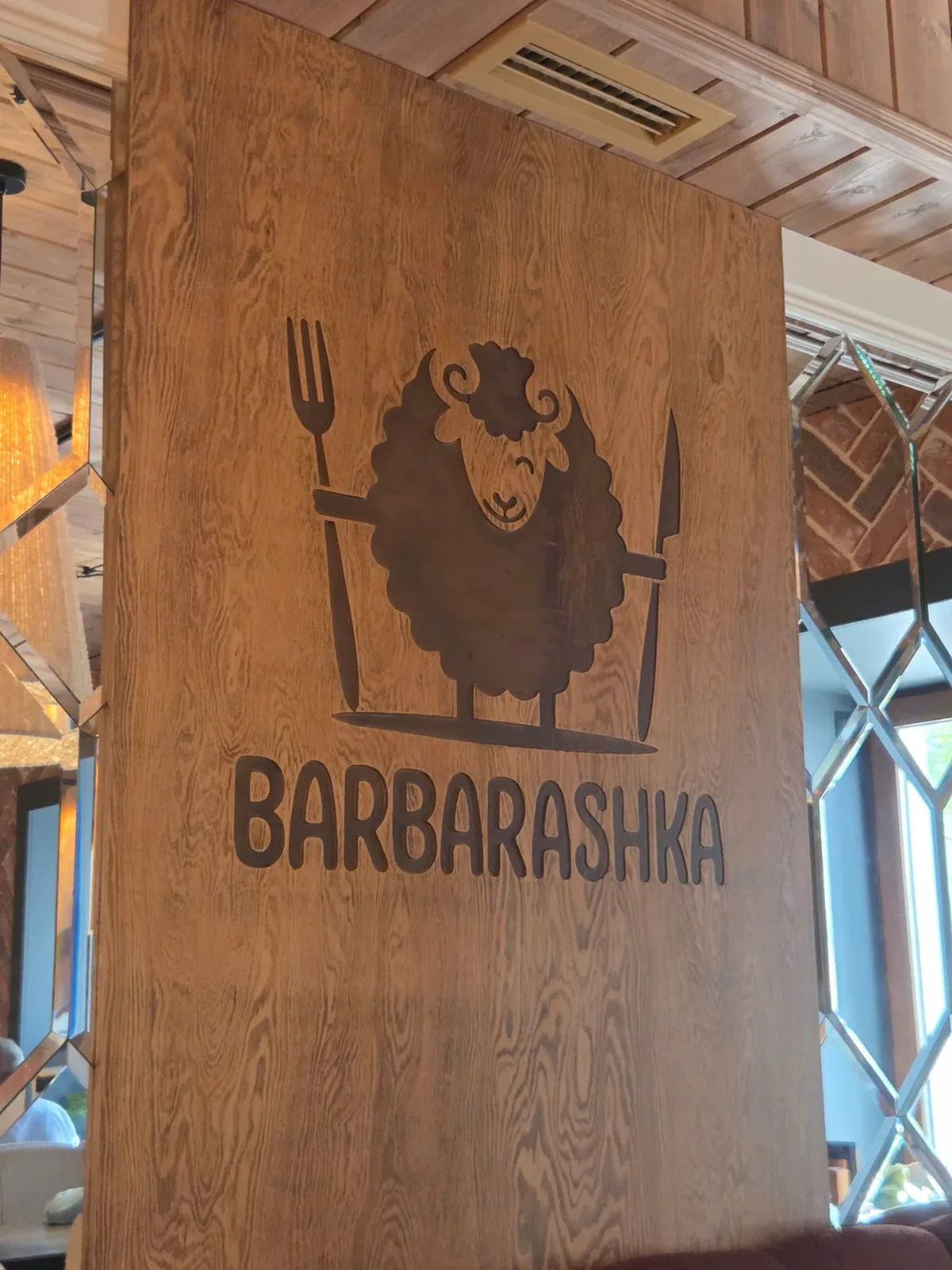 Фирменный знак Barbarashka — барашек с вилкой и ножом, вырезанный на деревянной панели