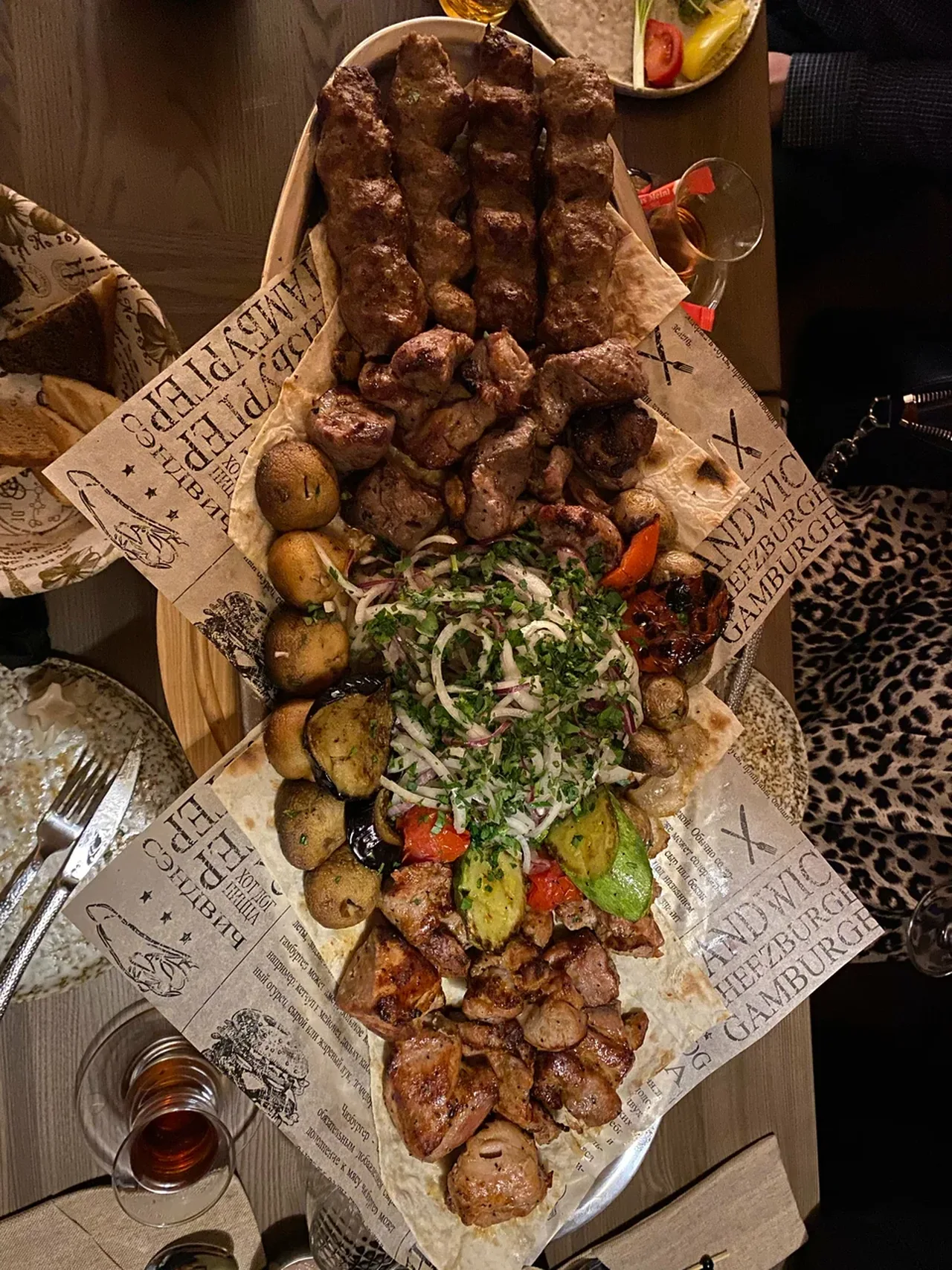 Большое ассорти мяса с углей на подносе с лавашом — люля, шашлык, печёный картофель
